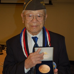 Frank Tanabe holds a replica of the Congressional Gold Medal in Washington, D.C., awarded collectively to Japanese-American veterans of World War II, including those who served in his unit, the Military Intelligence Service, November 2011 (Credit: Irene Tanabe)