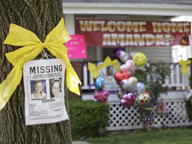 A missing person poster for Amanda Berry, one of the three woman found alive after vanishing for about a decade in their own neighborhood, is pictured on a tree in front of the home of Berry's sister Beth, which is adorned with balloons and a welcome home banner for Amanda, in Cleveland, Ohio May 7, 2013 (Credit: Reuters/John Gress)