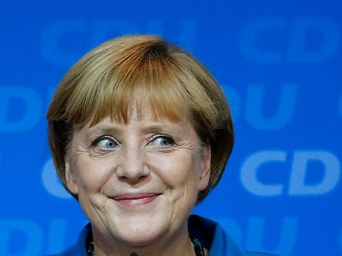 German Chancellor and leader of the Christian Democratic Union (CDU) Angela Merkel smiles as she addresses supporters after first exit polls in the German general election (Bundestagswahl) at the party headquarters in Berlin September 22, 2013 (Credit: Reuters/Fabrizio Bensch)