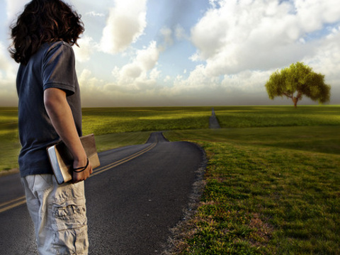 Teenager holding a Bible looking down a long and winding road (Credit: Keoni K via Lightstock)