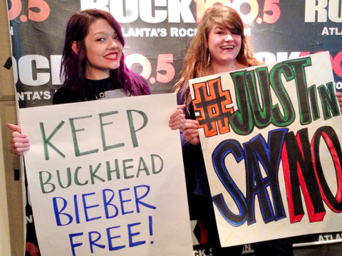 Employees of 100.5, a Cumulus radio station in Atlanta, hold up protest signs to keep Justin Bieber out of Atlanta's Buckhead neighborhood as part of a hoax conducte by The Regular Guys on Rock 100.5 (Credit: 100.5 Cumulus Radio/The Regular Guys on Rock)