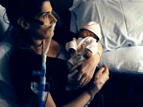 Elizabeth Joice, holding her newborn baby girl, Lily, while she lay critically ill in a hospital bed (Credit: CNN via Youtube)
