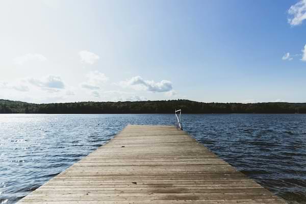 A wooden dock overlooking a tranquil blue lake