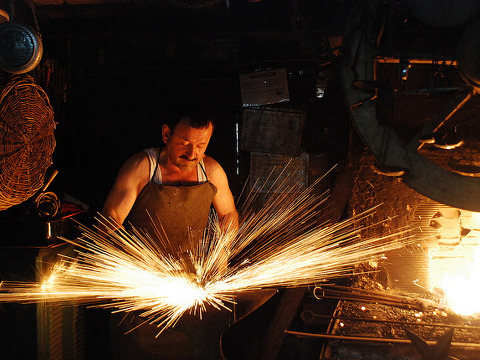 A blacksmith, working in his shop in the City of Safranbolu in the Province of Karabuk, Turkey, creates sparks as he hammers a piece of iron on his anvil (Credit: ilker ender via Flickr)