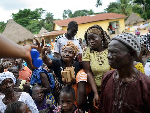 Members of the World Health Organization and the Red Cross hand out chlorine and medical soap to combat the spread of the Ebola virus in Bawa, Guinea, on July 10, 2014 (Credit: The New York Times/Redux/Samuel Aranda)