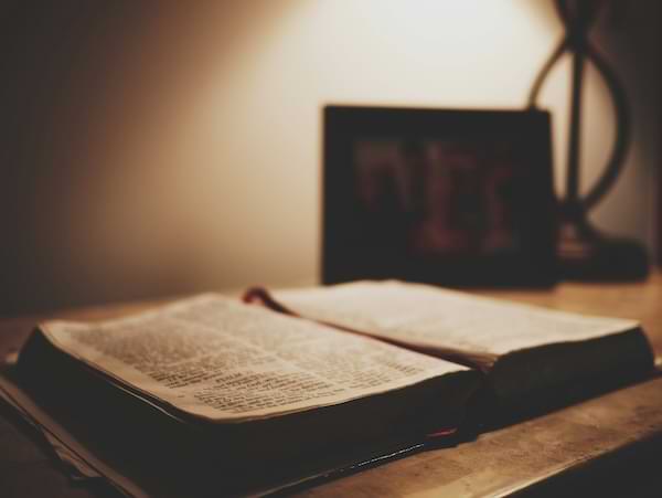 sepia tone image of an open Bible on an wooden table