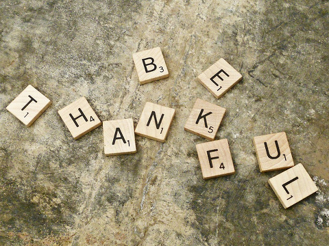Scrabble tiles spell out 'be thankful' on a galvanized surface (Credit: Cindi Albright via Flickr)