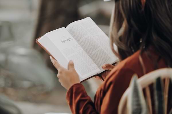 Young woman reading Proverbs from the Holy Bible