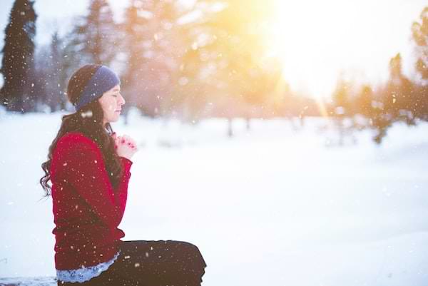 Woman praying silently in the snow