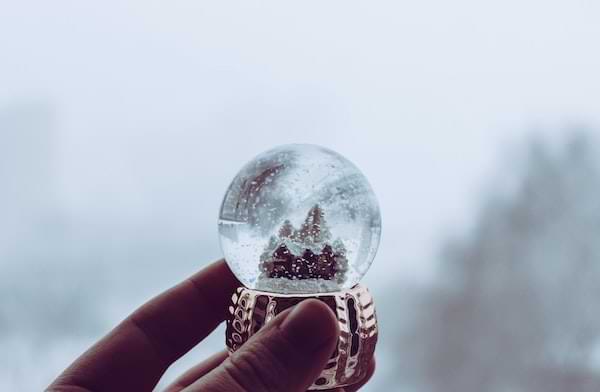 A small snow globe being held in a hand