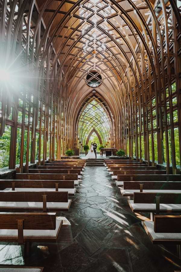 Bride and groom at the altar in a church with sunbeams shining through the windows