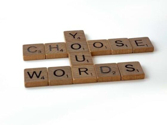 scrabble squares that spell out "choose your words" in a crossword puzzle fashion on a white backdrop