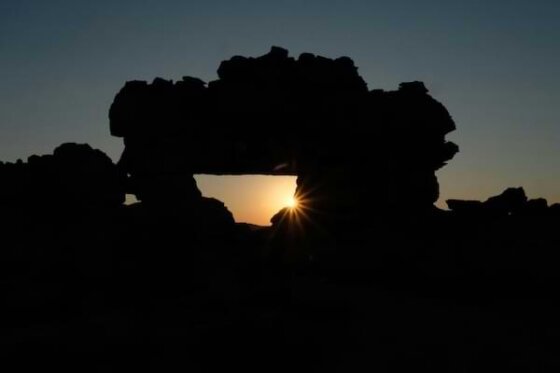 The morning star peering through ancient ruins cast in shadows