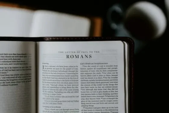 A black Holy Bible opened to the book of Romans